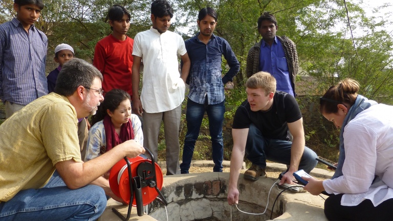 India Winterim participants and local colleagues conducting fieldwork at a well